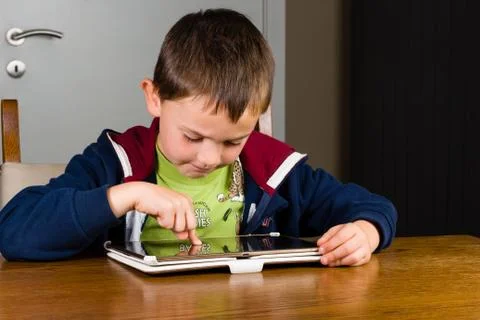 Young boy playing on tablet computer Stock Photos