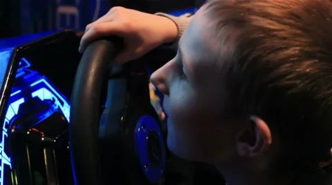 Young  boy playing video games at indoor amusement park. Stock Footage 64819692