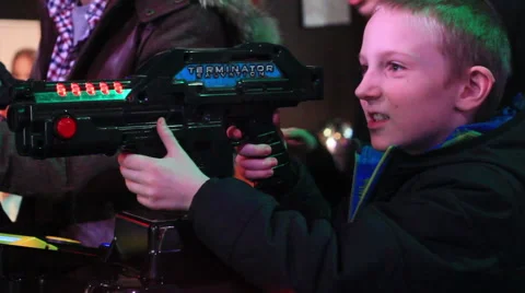 Young  boy playing video games at indoor amusement park. Video stock 64821093