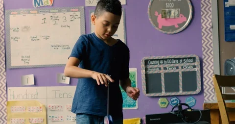 Young boy playing with a yo-yo in a classroom Stock Footage 108786848