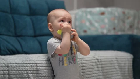 Young boy plays and simultaneously watches cartoons on TV in the room. Stock Footage 197547596