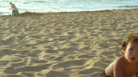 A young boy plays in the sand at the beach Stock Footage 33894305