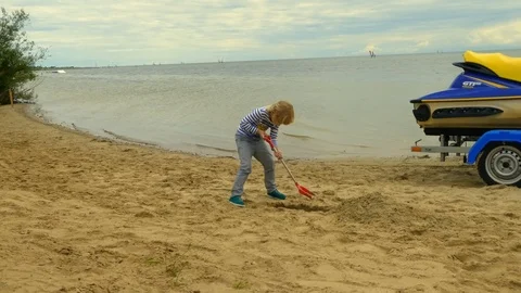 Young boy plays with sand toy at the beach. Stock Footage 115668564