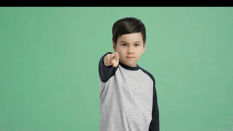Young  boy pointing out with his finger - Alpha Channel, Green Screen Stock Footage 129347348