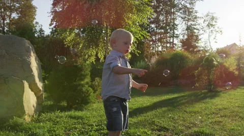 Young Boy Poke Bubbles Sunlight - 4k - Slow motion Stock Footage 61105663