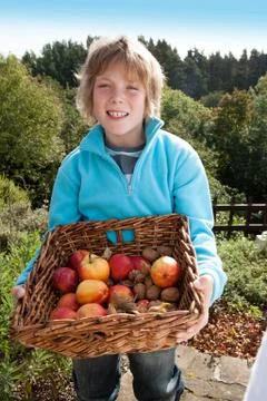 Young boy posing with a basket of hand-picked fruit Stockfoto's