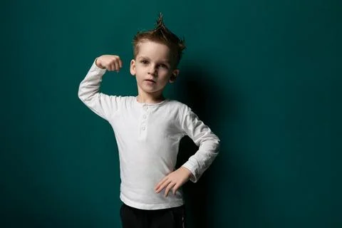 Young Boy Posing in Front of Green Wall Fotos Stock