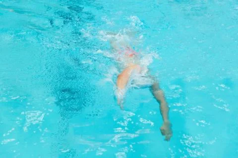 A young boy pounds in the pool. Stock Photos