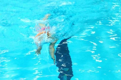 A young boy pounds in the pool. Stock Photos