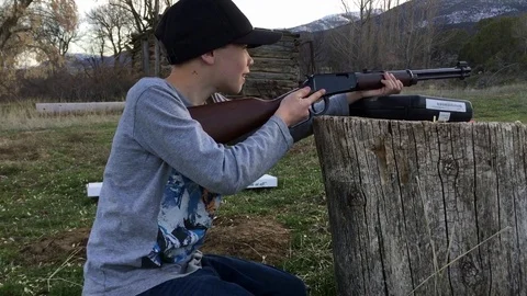 Young Boy practices target shooting with rifle HD Video stock 73709949