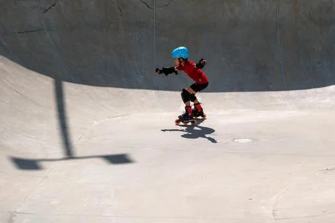 Young Boy Practicing Inline Skating in Concrete Skatepark Bowl Stock Photos