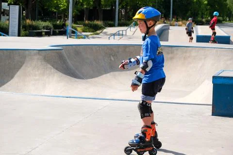 Young boy practicing inline skating at outdoor skatepark Stock Photos