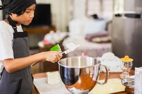 Young boy preparing ingredient for baking cake in kitchen. Stock Illustration
