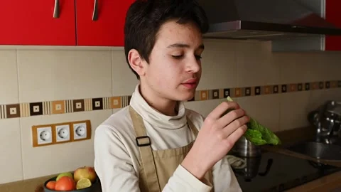 Young Boy Preparing Ingredients in a Kitchen with Red Cabinets Stockbeeldmateriaal 301813808