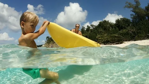 Young boy pulling mom in kayak on shallow tropical beach, St. John Video stock 118779116