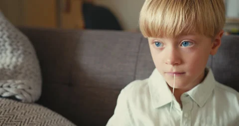 Young boy pulling out his own loose baby tooth with a string Stock-Footage 346982962