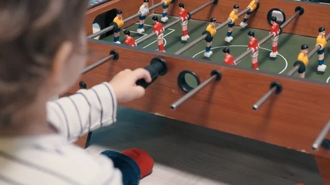 Young boy pulls the pens of table football Stock Footage 106064264