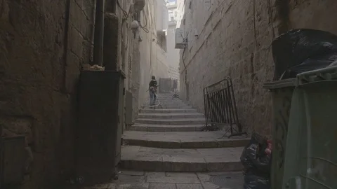 A young boy pulls a wheeled object up a set of old steps Stock Footage 82832851