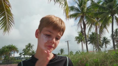Young boy putting on sunscreen at the beach Vídeo Stock 172164110