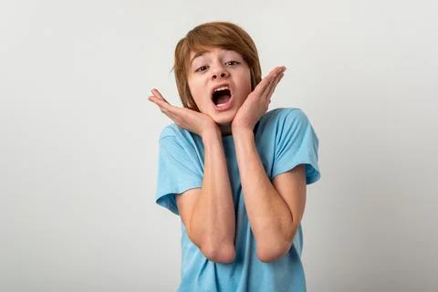 Young boy reacting with a shocked expression, mouth wide open, and hands pl.. Stock Photos