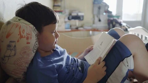 Young boy reading a book on the bed Stock-Footage 82288917