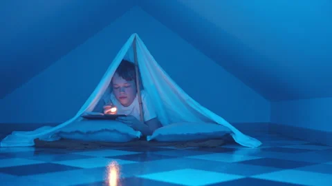 Young Boy Is Reading An Interesting Book In Tent Tipi At Home Under The Cover Stock Footage 170225147
