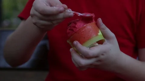 Young boy in red eating strawberry ice cream outdoor Stock Footage