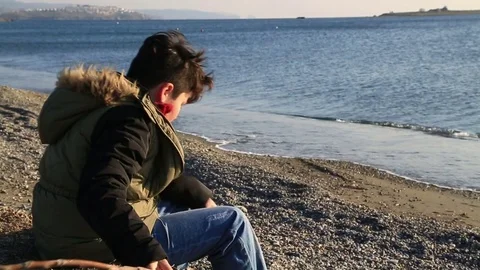 Young boy relaxing at the seaside Stock Footage 71750759