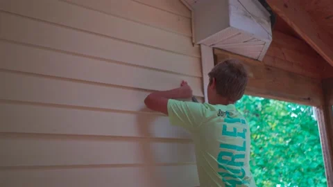 Young Boy Removing vinyl siding on home repair project Vídeo Stock 157645135