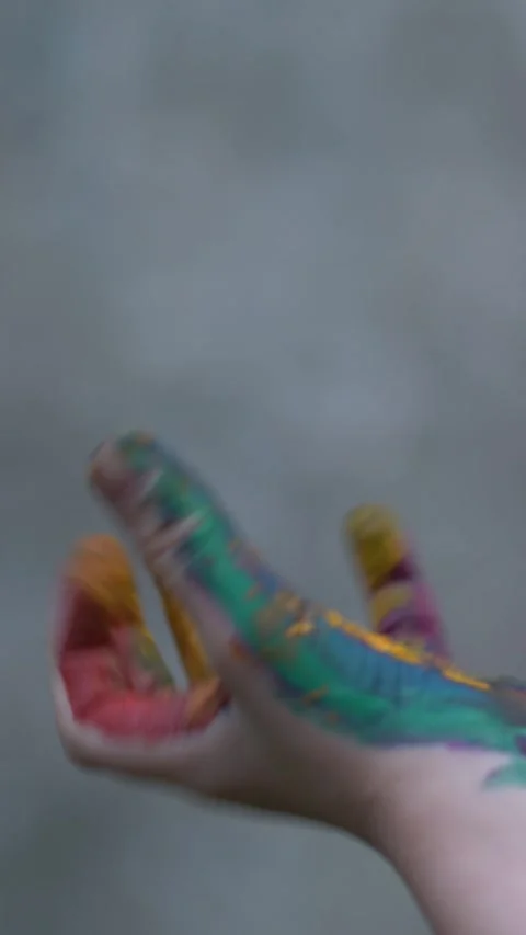 Young boy repeatedly opens and closes his paint-smeared hand. Video stock 342570521