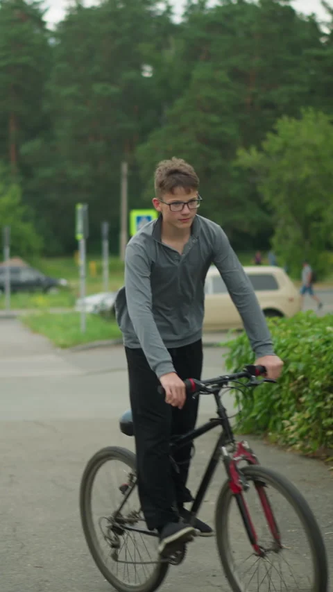 Young Boy Riding Bicycle on Interlock Path in Quiet Suburban Setting Surrounded Stock Footage 310811594
