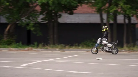 Young boy riding a motorcycle doing tricks Stock-Footage 98493230