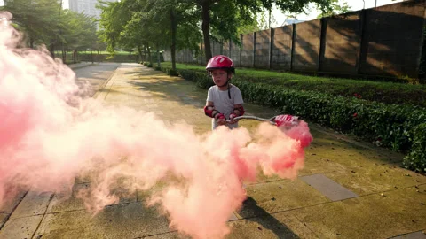 Young boy on roller skates holding a pink smoke bomb on stick Stock Footage 303624761