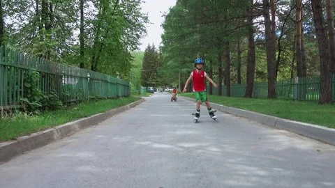 Young boy roller skating on the road Stock Footage 77588370