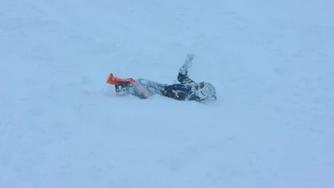 Young Boy Rolling Down a Hill through Fresh Snow Stock Footage 102928566