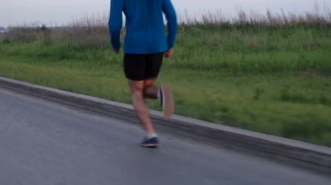 Young boy running along the road Видео 64618366