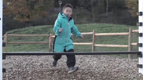 Young boy running and jumping over a hurdle, slow motion Stock Footage 221100774