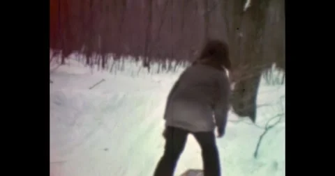 Young boy running and sledding in the woods, authentic archival winter 動画素材 328114875