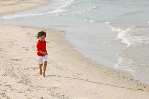 Young boy running on beach Stock Photos