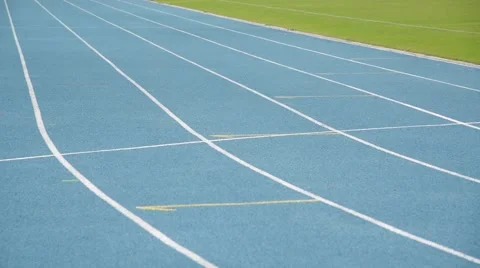 Young boy running on blue track in the stadium in day time to practice himself Stock Footage 56054067