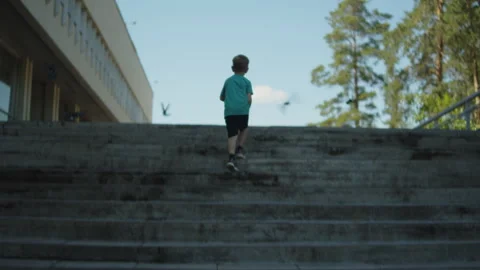 Young boy running up a concrete staircase.  Kid going up a staircase outside. Stock-Footage 343209834