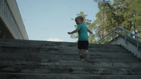 Young boy running up a concrete staircase. Active child climbing tall steps Vídeos de archivo 343209983