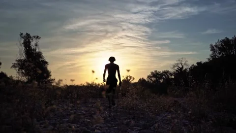 Young boy running in slow motion at sunset Stock Footage 323762739