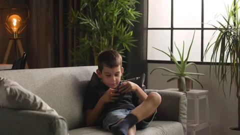 Young Boy Running to Sofa to Play Game on Smartphone 스톡 동영상 344146941