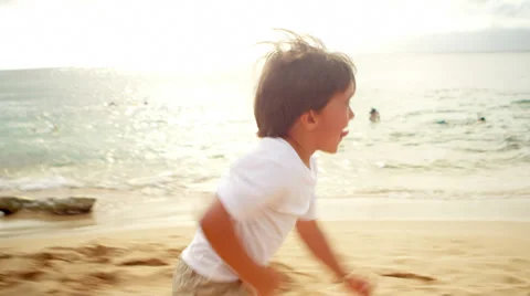 A young boy runs down the sand and jumps into his dad's arms Vidéo 33896104