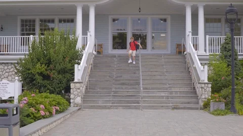 Young Boy Runs Down the Steps as His Mother Pulls Up Car in Front of School Stock Footage 113436847