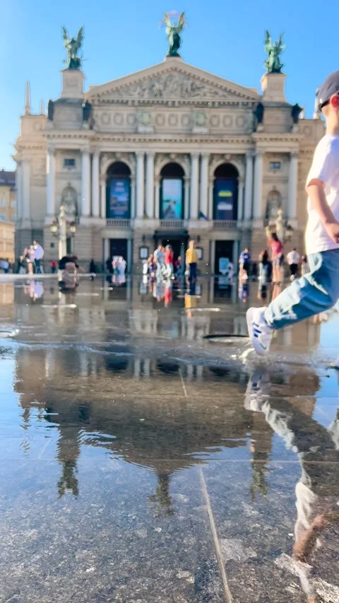 A young boy runs through the water of the fountain. Vídeo Stock 339086042