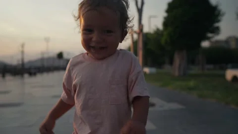 A young boy runs while laughing out loud. The happy toddler is having a 스톡 동영상 208698213