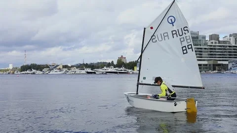 Young boy sails by lake on small boat of Yacht Stock Footage 299624485