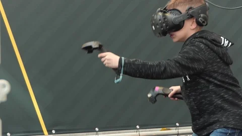 Young boy is scared while playing with virtual reality glasses and joysticks Vídeo Stock 104098532